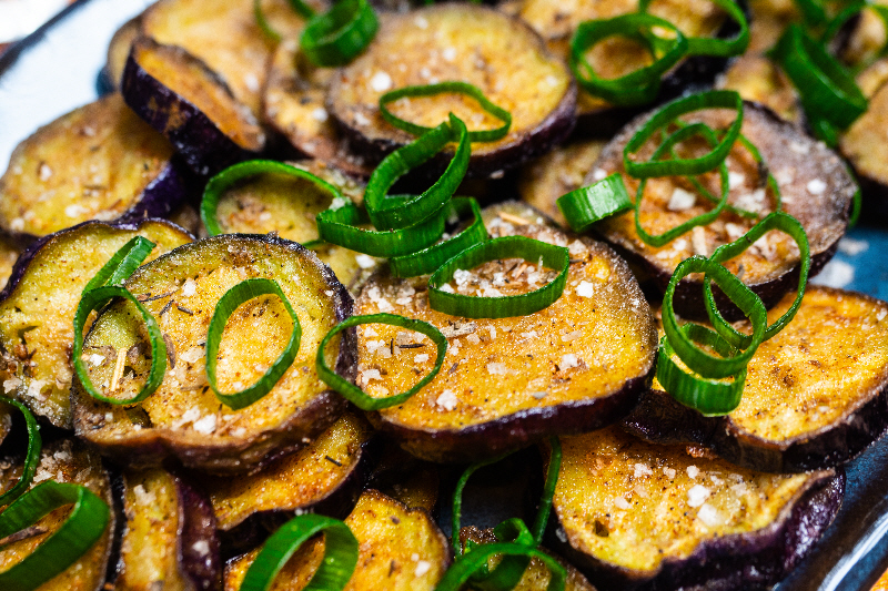 Fried aubergine topped with chopped spring onions
